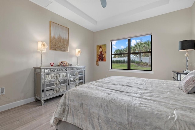 bedroom featuring a tray ceiling, ceiling fan, and hardwood / wood-style flooring