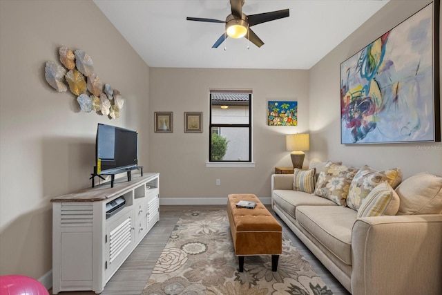 living room featuring ceiling fan and dark wood-type flooring