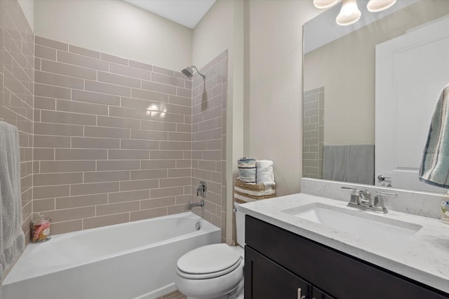 full bathroom with vanity, toilet, and tiled shower / bath