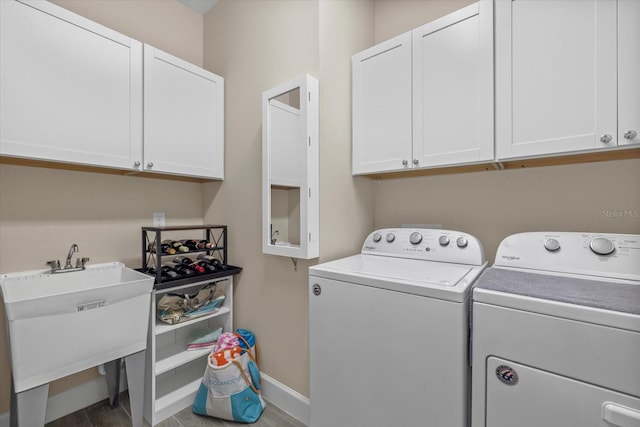 laundry area featuring washer and dryer, sink, and cabinets