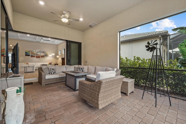 view of patio featuring ceiling fan and an outdoor living space with a fire pit