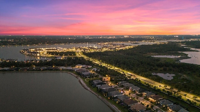 aerial view at dusk featuring a water view