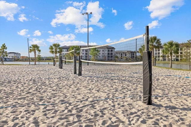 view of community with volleyball court and a water view