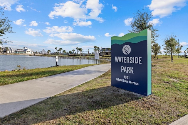 view of property's community with a lawn and a water view