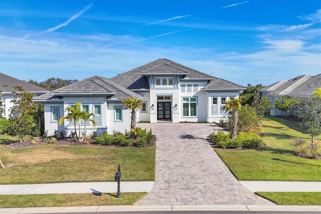 8544 Pavia Way, Bradenton, FL 34202 - view of front facade with stucco siding, french doors, a front yard, and decorative driveway