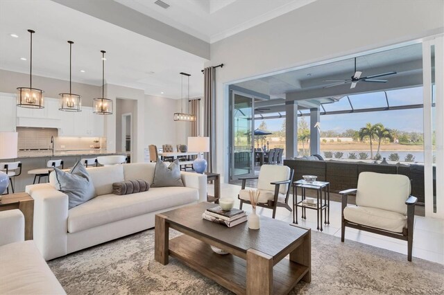 living room with ceiling fan, crown molding, and sink