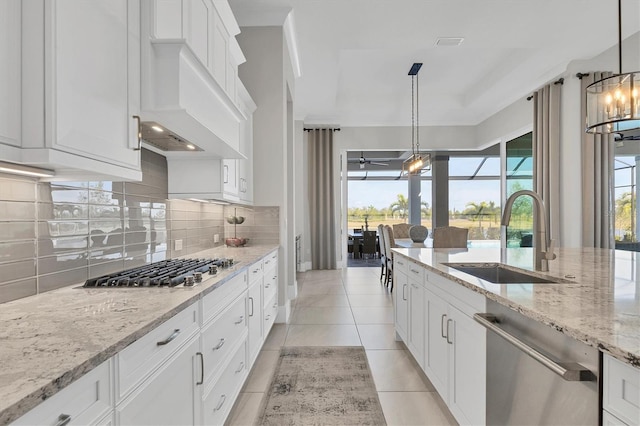 kitchen with white cabinets, stainless steel appliances, sink, and tasteful backsplash