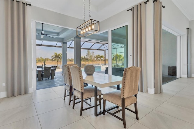 tiled dining room featuring a tray ceiling, plenty of natural light, and ceiling fan