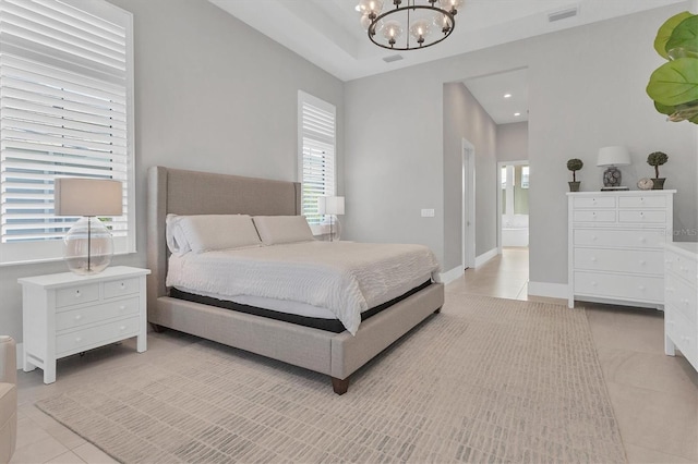 tiled bedroom with connected bathroom and an inviting chandelier