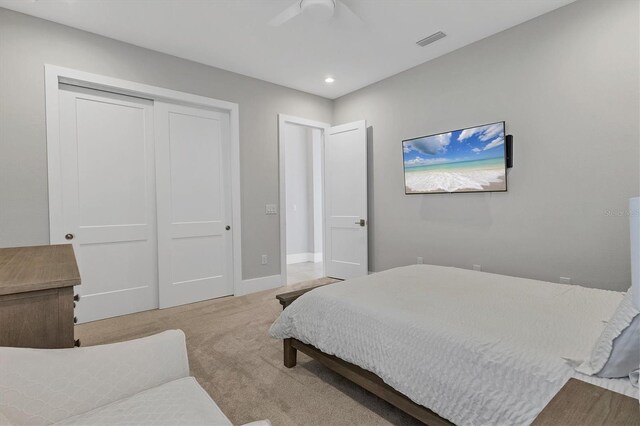 carpeted bedroom with ceiling fan and a closet