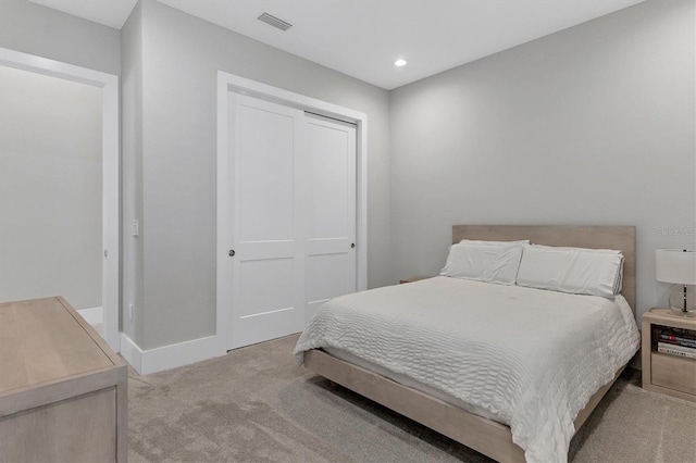 bedroom featuring light colored carpet and a closet