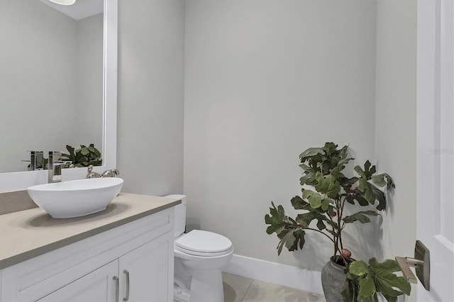 bathroom with tile patterned flooring, vanity, and toilet