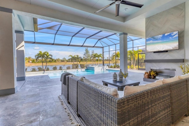 view of patio featuring an outdoor living space with a fireplace, ceiling fan, a lanai, and a water view