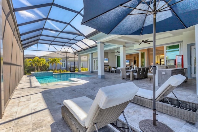 view of swimming pool featuring glass enclosure, ceiling fan, a patio area, and a bar