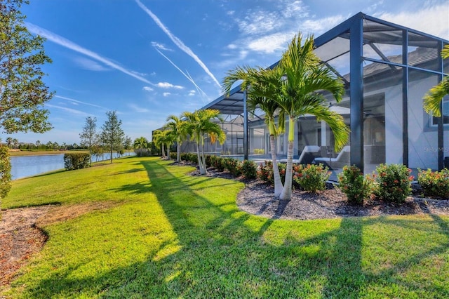 view of yard with a lanai and a water view