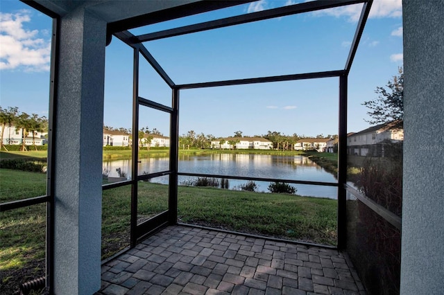 unfurnished sunroom featuring a water view