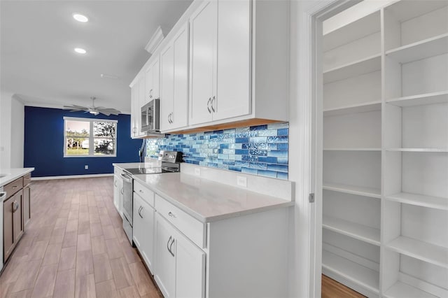 kitchen featuring white cabinetry, ceiling fan, tasteful backsplash, light hardwood / wood-style flooring, and appliances with stainless steel finishes