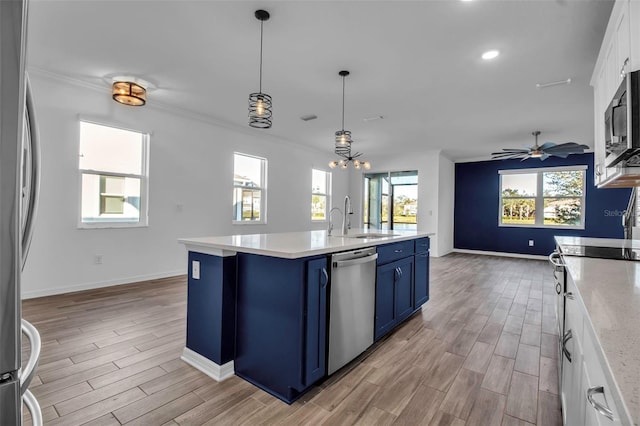 kitchen with appliances with stainless steel finishes, light wood-type flooring, blue cabinets, sink, and white cabinets