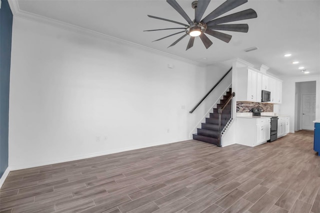 unfurnished living room featuring hardwood / wood-style floors, ceiling fan, and crown molding