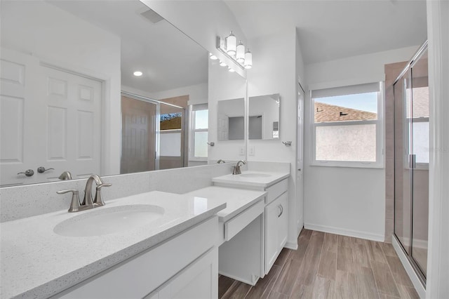 bathroom featuring hardwood / wood-style flooring, vanity, and a shower with shower door