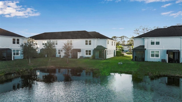 back of house featuring a yard and a water view