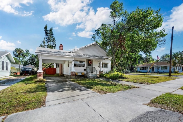 view of front of property with a front lawn and a carport