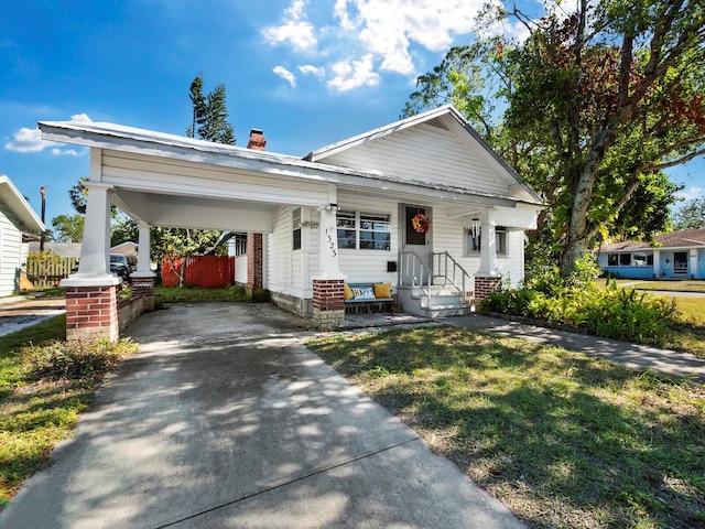 view of front of property featuring a front lawn and a carport