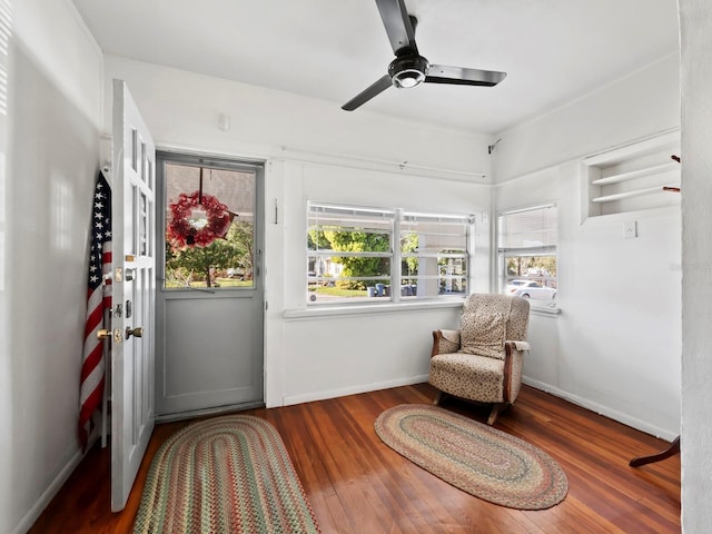 sitting room with ceiling fan and dark hardwood / wood-style flooring