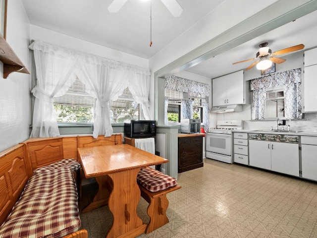 kitchen featuring white cabinets, white range oven, ceiling fan, and sink