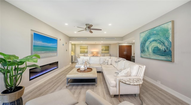 living room featuring light hardwood / wood-style floors and ceiling fan