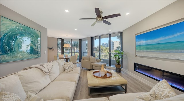 living room with light wood-type flooring and ceiling fan