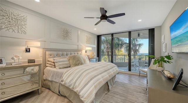 bedroom featuring floor to ceiling windows, access to outside, light hardwood / wood-style floors, and ceiling fan