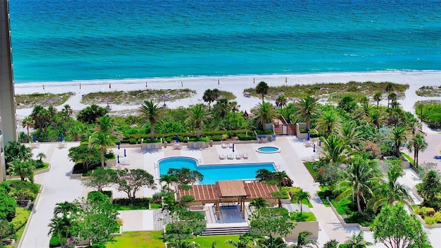 birds eye view of property with a water view and a beach view