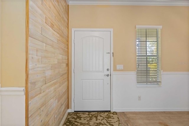 entryway featuring crown molding and wood walls