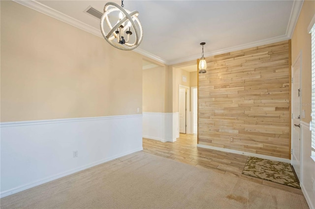 empty room with light hardwood / wood-style flooring, crown molding, and a notable chandelier