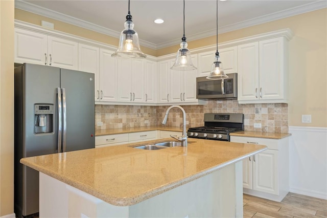 kitchen with light stone countertops, white cabinetry, sink, stainless steel appliances, and light hardwood / wood-style flooring