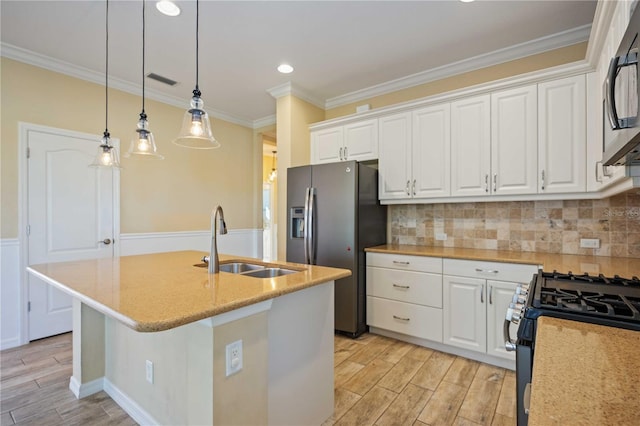 kitchen with a kitchen island with sink, sink, white cabinets, and stainless steel appliances