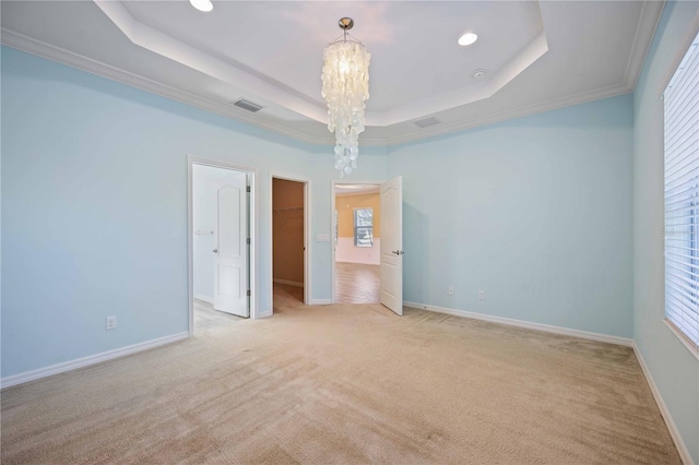 unfurnished room with crown molding, a wealth of natural light, and a tray ceiling