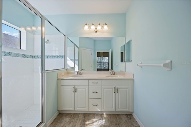 bathroom with hardwood / wood-style floors, vanity, and an enclosed shower