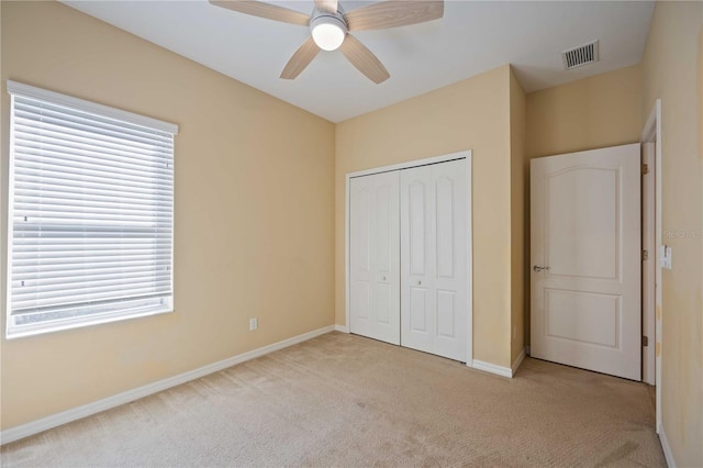 unfurnished bedroom with ceiling fan, a closet, and light colored carpet