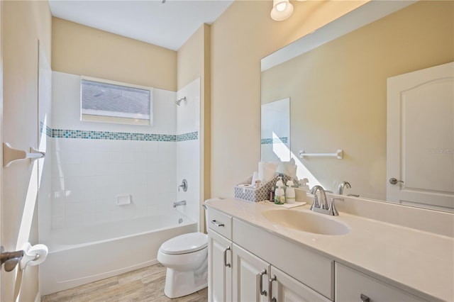 full bathroom featuring vanity, wood-type flooring, tiled shower / bath combo, and toilet