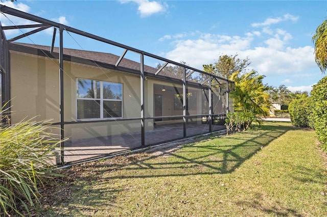 exterior space featuring a yard, a patio, and glass enclosure