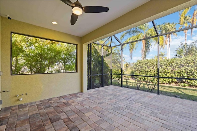 unfurnished sunroom featuring ceiling fan