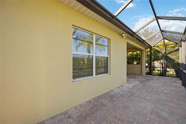 view of patio featuring glass enclosure