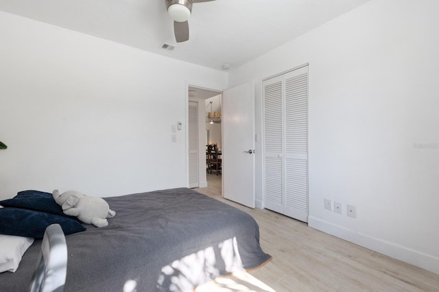 bedroom with a closet, light hardwood / wood-style flooring, and ceiling fan