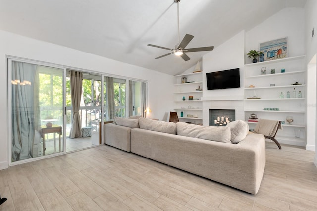 living room featuring ceiling fan, light hardwood / wood-style flooring, high vaulted ceiling, and a brick fireplace