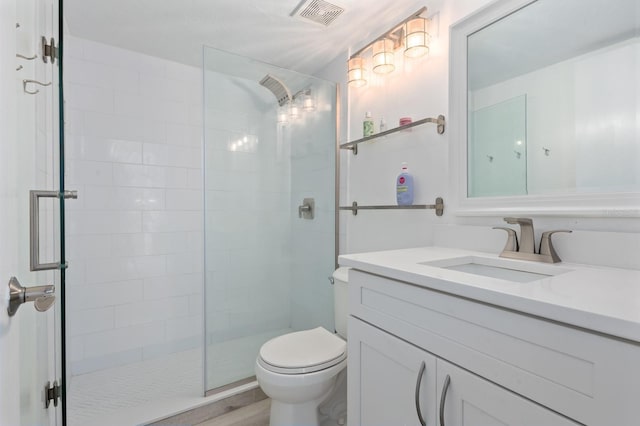 bathroom with wood-type flooring, vanity, toilet, and walk in shower