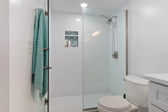 bathroom featuring vanity, toilet, and a shower with shower door