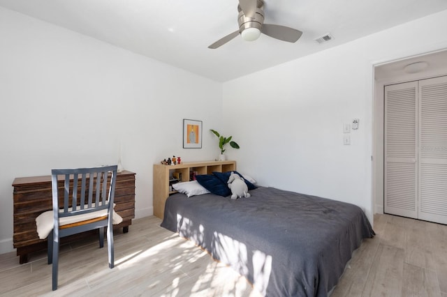 bedroom featuring ceiling fan, light wood-type flooring, and a closet