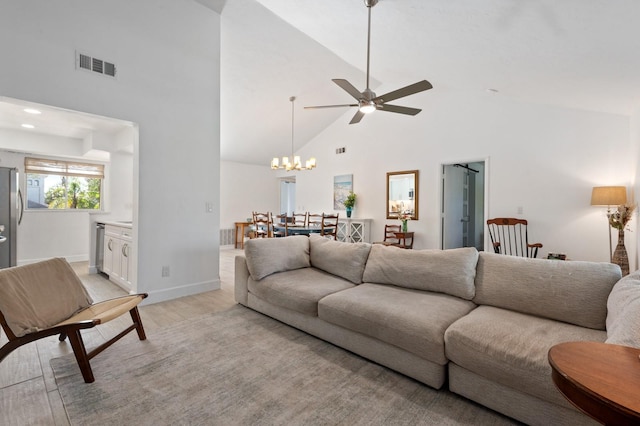 living room with ceiling fan with notable chandelier, light wood-type flooring, and high vaulted ceiling